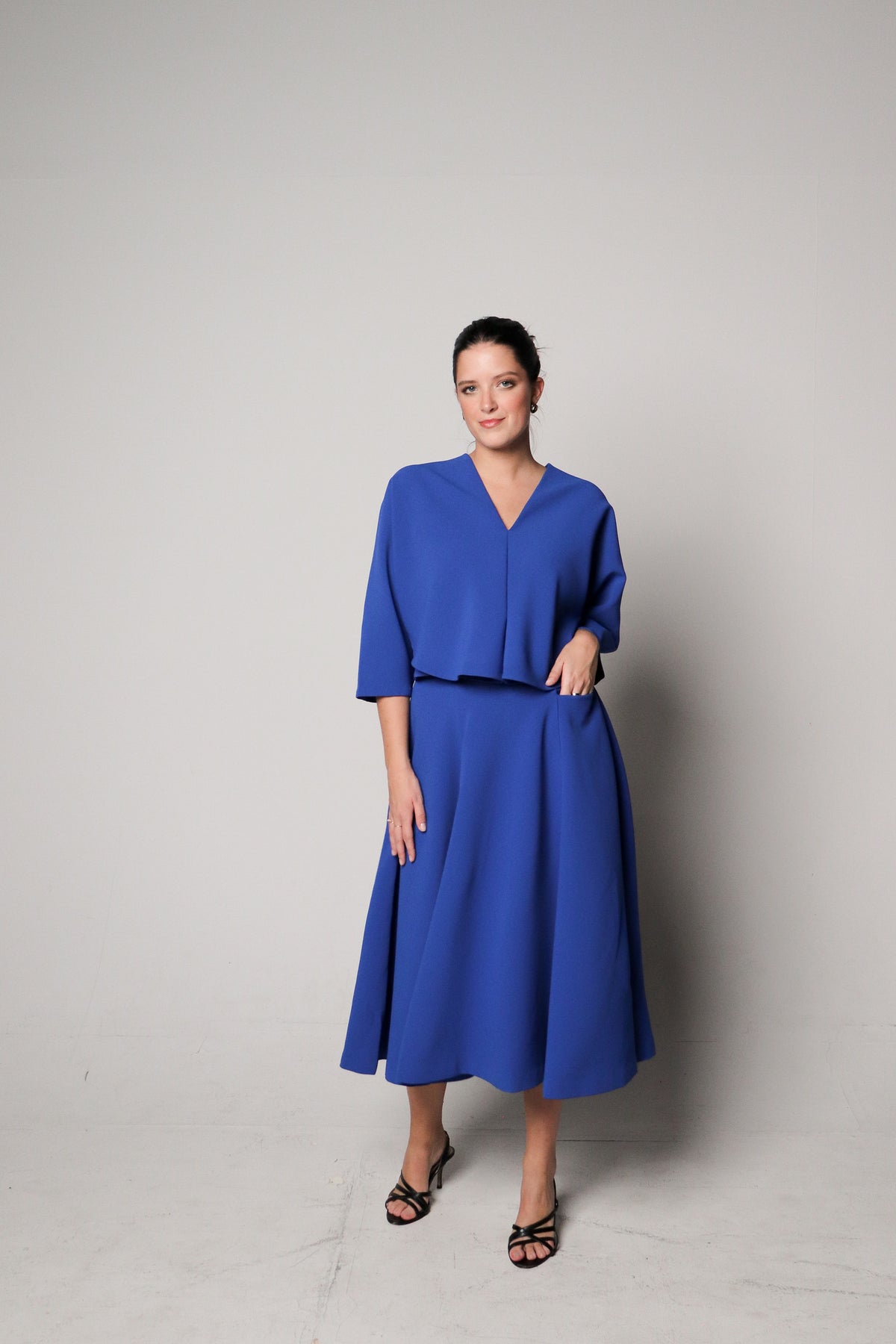 Woman wearing a blue dress against a plain background