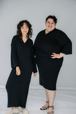 gabby and jules wear the mr mittens ribbed v neck dress in black ribbed cotton. they are both smiling at the camera.