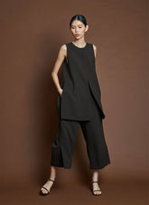 julia, an asian woman, wears the kaarem bambu pants in brown paired with an oversized sleeveless top with center seam