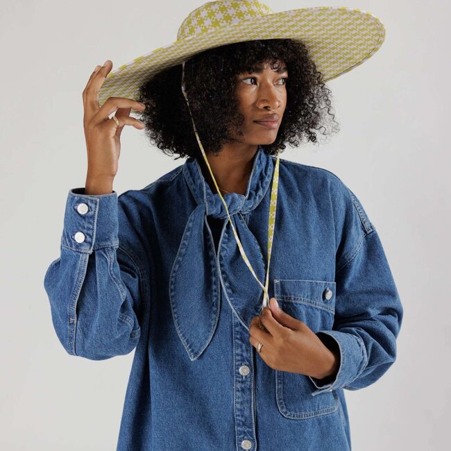 a woman wears the baggu packable sunhat in gingham pixel