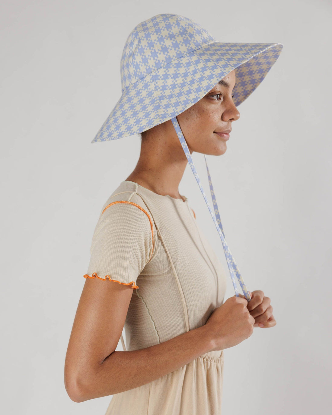 a woman wears the soft sun hat in gingham pixel