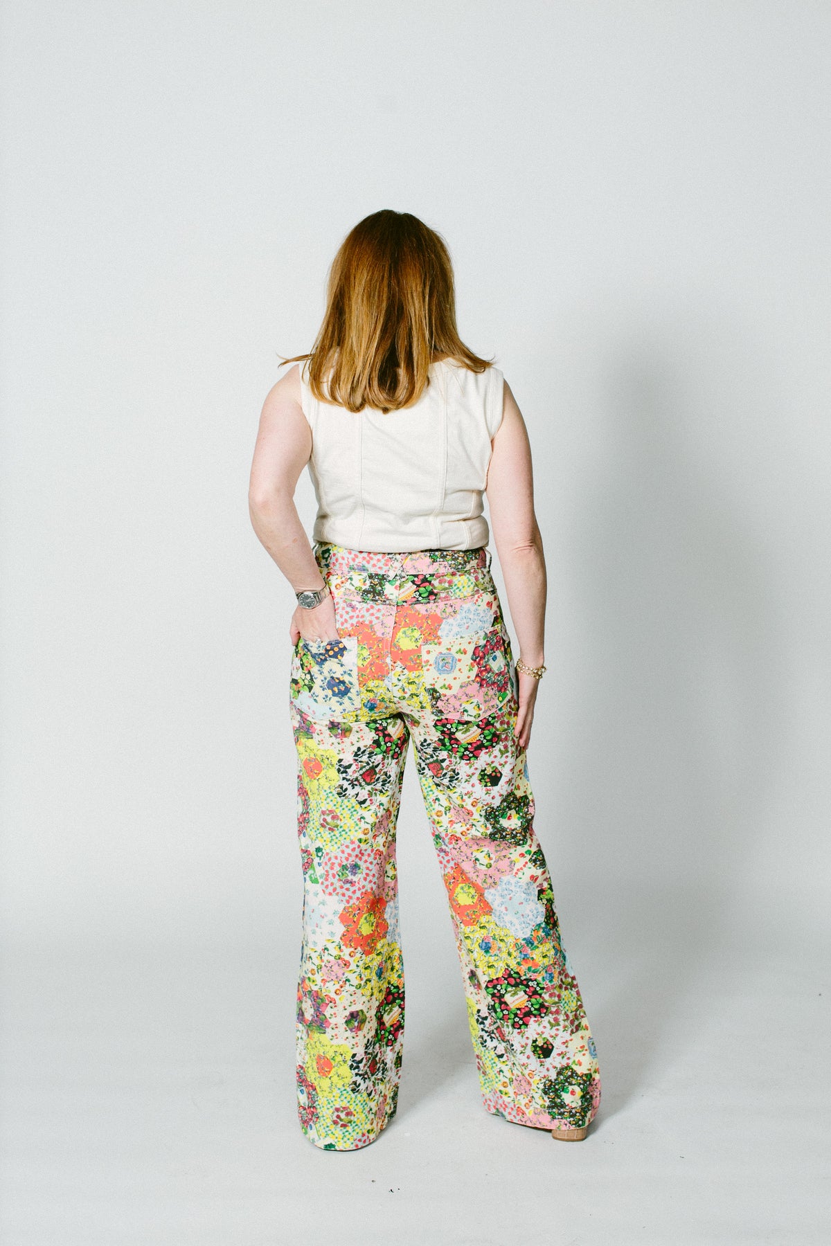 marisa, a white woman, wears the alabama chanin ivory corset top with some over the top floral rachel antonoff pants.