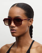 a woman wears the machete jane sunglasses in oxblood