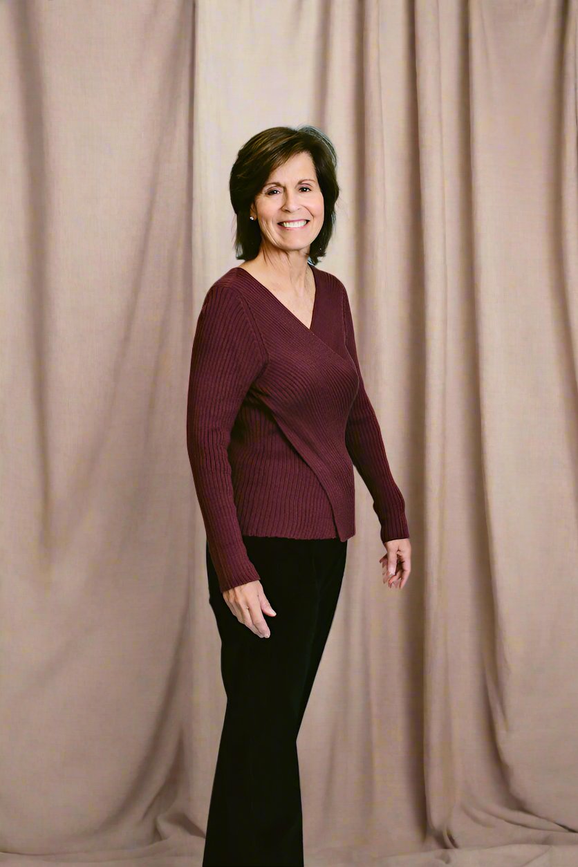 a woman with short brown hair wears the shaina mote didion sweater in plum with black pants